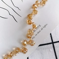 Macro shot of amber faceted crystal waterdrop beads showing high gloss and warm golden tones - Faceted Water Drop and Round Bead Style / Strand Style / Champagne Amber (2#)
