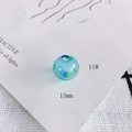 Macro shot of 13mm light blue hollow glass bead with artistic dark blue and green spots - 11# Style (KP4175)