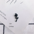 Vue macro d'un pendentif rose noir mat 23x9mm pour création de bijoux DIY sur fond décoratif - Rose Noire (15#)
