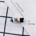 Macro detail of 28x14mm handmade ceramic fish pendant with painted pink flower motifs - White Plum Blossom Pattern (1#)