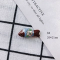 Macro view of blue enamel fish pendant with pink flowers and gold trim detailing - Light Blue and Maroon Vintage (6#)