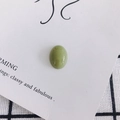 Macro shot of oval green acrylic resin bead on elegant white card and checkered background - Emerald Green (Style 7)