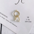 Close-up of elegant gold plated crystal pave round pendant with white pearls - Size 9