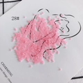 Detailed view of 2mm pink translucent glass seed beads artfully arranged on paper - 450g Pack (Approx. 57600 Pcs) / 28#