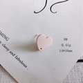Dettaglio macro di un ciondolo a cuore in acrilico rosa opaco 14x16mm con foro praticato - Rosa Carne (9#)