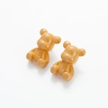 Macro detail of cartoon gummy bear earrings with polished caramel resin finish - Brown