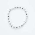 Detalle de perlas blancas brillantes y cuentas plateadas facetadas en una pulsera elástica - Plata Mixta