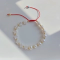 Detailansicht eines handgemachten roten Perlenarmbands mit Perlmutt-Seestern-Anhängern - Perlenstern