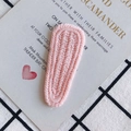 Primer plano de pasador de pelo tejido a mano en rosa con textura detallada en forma de V - Rosa