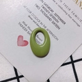 Detail view of oval grass green resin jewelry pendant on a wedding invitation card - Lime Green