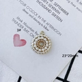 Macro detail of a 23x20mm gold alloy circular pendant with inlaid pearls and pink beads - Champagne (3#)