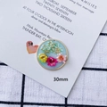 Detail shot of a 30mm handmade resin pendant with colorful dried flowers and gold leaf - Round Pink Yellow Flower Style (1#)