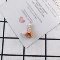 Détail d'un pendentif fleur en tissu avec perle blanche et filigrane doré pour bijoux - Champagne