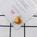 Detailed view of yellow satin fabric flower pendant with a white pearl and gold metal bead cap - 17# Ginger Yellow