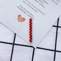 Detalle macro de colgante de barra de cristal rojo y acabado dorado para joyería - Estilo rojo