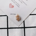 Detail view of a 18x12mm pearl charm with gold wire wrap and a secure metal hanging loop - Spiral Texture Hanging Loop Style (10#)