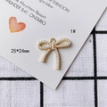 Vue macro d'un pendentif nœud doré de 25x24mm avec perles blanches et anneau de suspension - Nœud Pavé de Perles (1#) / 5 Pièces