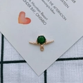 Detailansicht eines goldenen Ohrringanhängers in Flügelform mit grünem Edelstein - Einzelner Anhänger / Grün (1#)