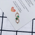 Macro detail of alloy gold plated infinity bow connector with green stones and zircons - Emerald Style (3#)