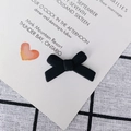 Macro-opname van matzwarte strikvormige sieradenaccessoire op elegant papier - Zwart