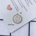 Dettaglio del ciondolo a rosa da 24x21mm in lega dorata con strass bianchi brillanti - Linea Rosa Dorata Base Bianca Bordo Strass Stile Rotondo (6#)