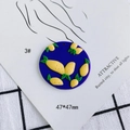 Détail macro d'un pendentif en argile bleue de 47x47mm avec motifs citron 3D et feuilles - Style Rond Citron Bleu Foncé (3)
