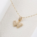 Dettaglio macro del ciondolo a lettera W in oro con pavé di zirconi scintillanti su catena - Lettera W