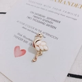 Detailansicht eines goldenen Flamingo-Ohrrings mit weißem Emaille-Flügel auf Einladung - Off-White (Rechts)