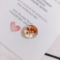 Close-up of semi-round clear resin charms with dried orange flowers for DIY earrings - Orange Dried Flower Inlaid Style