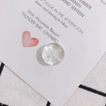 Macro shot of a faceted transparent resin charm with an embedded white dried flower petal - White Dried Flower Faceted Style