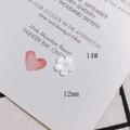 Gros plan d'une fleur de nacre blanche de 12 mm sculptée pour création de bijoux DIY - Fleur à trou central 12mm (14#)