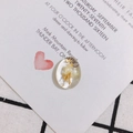Close-up of oval acrylic pendant with embedded dried yellow flowers and gold foil accents - Yellow Flower Style (4#)