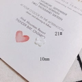 Macro d'une perle fleur en nacre de 10mm pour bijoux DIY sur tissu texturé blanc - Fleur blanche à quatre pétales 10mm (21#)