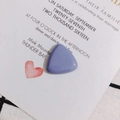 Macro view of light purple resin triangle charm for DIY jewelry on a white card - Gray Blue