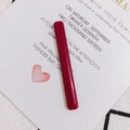 Detalle de un accesorio rectangular de acrílico burdeos brillante en una tarjeta de invitación - Rojo