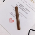 Detalle de una pinza para el cabello larga de acrílico café en una tarjeta blanca - Café