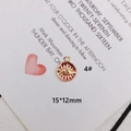 Detail of a 15x12mm evil eye pendant with red enamel and wavy golden edge - Round Red Evil Eye Style (KP3108)