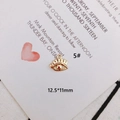 Macro shot of 12.5x11mm gold-plated eye-shaped alloy charm with closed loop for DIY jewelry - Eyelash Eye Motif Style (KP3108)