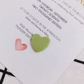 Détail macro de pendentif cœur en acrylique vert clair sur carte d'invitation chic - Vert matcha
