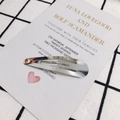 Primo piano di un fermaglio per capelli in metallo argento su carta decorativa - 68mm