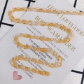 Macro detail of amber and clear acetate link chain for DIY accessories on white card - Size 9