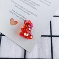 Macro detail of red transparent faceted acrylic bear pendant with iridescent aurora finish - Iridescent Red
