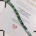 Macro view of iridescent arrow beads on wedding invitation card with metallic luster - String (Approx 114 Units) / Green
