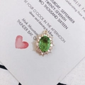 Macro view of vintage oval green crystal pendant with gold plating and white zircon frame - Grass Green