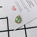 Macro shot of waterdrop pendant with real green dried flowers in gold metal edging - Green Plant Scraps (12#)