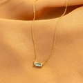 Collana dorata con ciondolo rettangolare in pietra blu su sfondo di raso giallo - Oro Marzo (Mar)