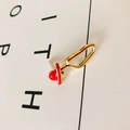 Macro-opname van goudkleurige oorbel met een detail van een rode geëmailleerde hoed - Gouden Frame Rode Hoed (1#)