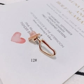 Detalle de pendiente en U de oro claro con gema rosa sobre una tarjeta blanca - Anillo en Forma de U con Gema Rosa (12#)