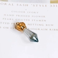 Detailed macro view of a golden crown pendant with faceted grey crystal and hanging loop - Gray (10)