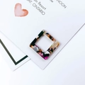 Macro shot of square acetate acrylic pendant with colorful terrazzo pattern for DIY jewelry - Purple Orange Terrazzo Pattern